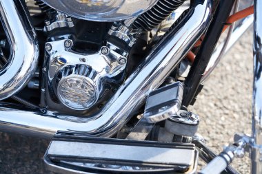 Krom motosiklet. Hisse. Üzerinde krom detaylar ve motosikletçi kıyafetleri olan yeni siyah motosikletin yan görüntüsü. Krom detaylar motosiklet yolculuktan önce bozkır manzarasını yansıtır