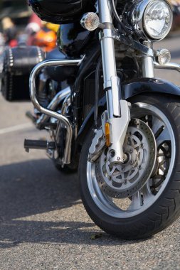 Krom motosiklet. Hisse. Üzerinde krom detaylar ve motosikletçi kıyafetleri olan yeni siyah motosikletin yan görüntüsü. Krom detaylar motosiklet yolculuktan önce bozkır manzarasını yansıtır