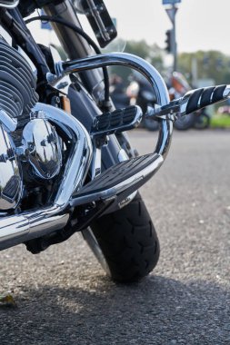 Krom motosiklet. Hisse. Üzerinde krom detaylar ve motosikletçi kıyafetleri olan yeni siyah motosikletin yan görüntüsü. Krom detaylar motosiklet yolculuktan önce bozkır manzarasını yansıtır