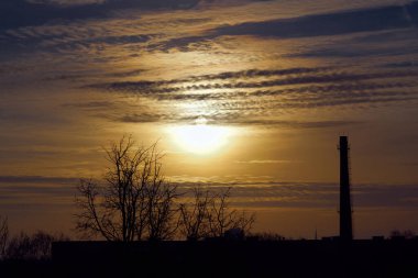 Turuncu gökyüzünde gümüş astar ve bulutla güçlü gündoğumunun muhteşem manzarası..