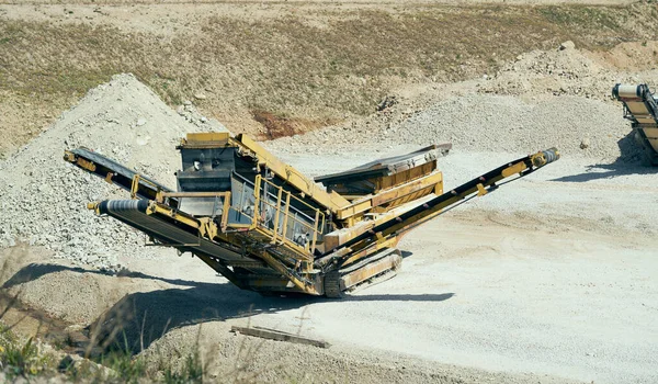 Mechanical machine, conveyor belt for transporting and crushing stone with sand. Mining quarry for the production of crushed stone, sand and gravel for use in the construction industry.