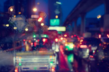 Yağmur damlaları, yol lambası Bokeh ile pencereye düşer yağmurlu mevsimlerde şehir hayatı soyut arka plan, camlara su damlası, gece fırtınası araba sürme konsepti.