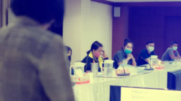 İş adamlarının Coronavirus 'u (Covid-19) toplantı odasında engellemek için maske taktıkları bulanık bir görüntü. Girişim ekibi atölyeyle ilgili beyin fırtınası yapıyor. 