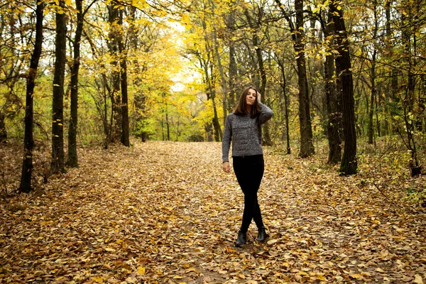 Cute girl in a gray sweater with braces on her teeth stands on t — Stock Photo, Image