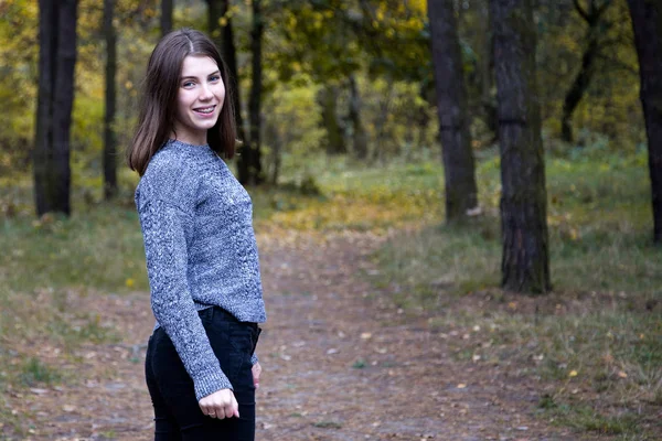 Cute girl in a gray sweater is half a turn on the road in the au — Stock Photo, Image