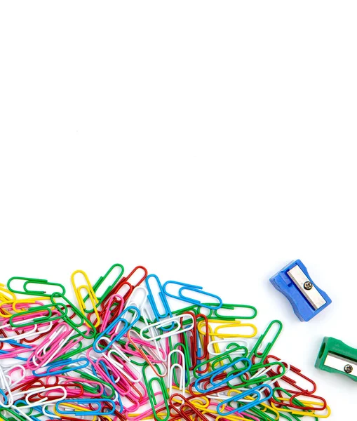 Um monte de clipes de papel coloridos e apontadores de lápis em um ba branco — Fotografia de Stock