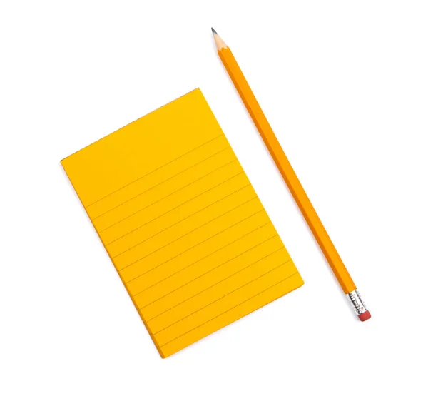 Un cuaderno de rayas con hojas de color naranja junto a la que se encuentra un agudo — Foto de Stock