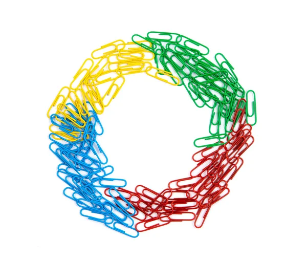 Una pila de clips de papel rojos, verdes, azules y amarillos se encuentra en el ce — Foto de Stock