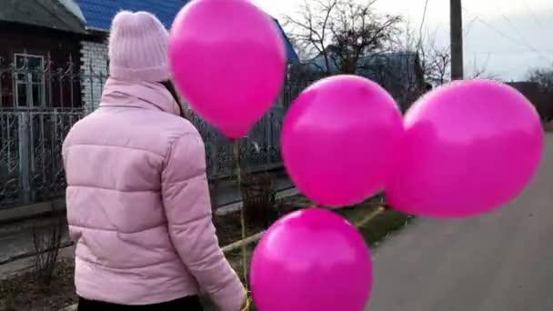 Bonita Chica Camina Por Calle Sosteniendo Globos Rosados Sonriendo Girando — Vídeos de Stock