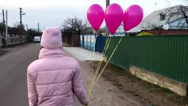 Söt Flicka Går Gatan Hålla Rosa Ballonger Händer Visa Från — Stockvideo