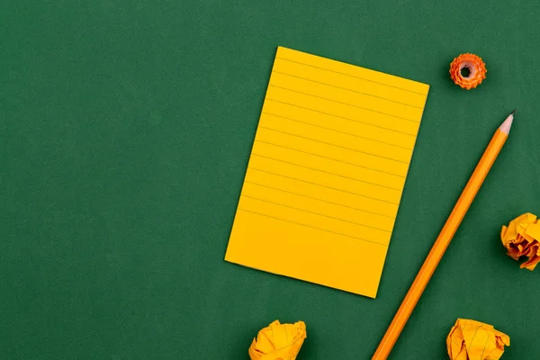 Uma folha de papel laranja encontra-se em um conselho escolar verde constituí — Fotografia de Stock