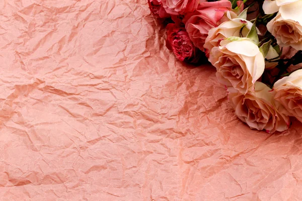 Un ramo de hermosas rosas sobre un fondo artesanal rosa con spa Fotos De Stock