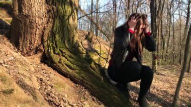 Güzel bir kız büyük bir ağacın altında oturuyor. Kız kayıp.