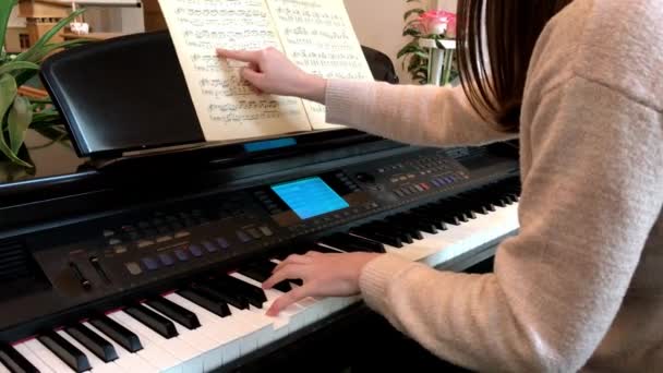 Κορίτσι που κάθεται από το πιάνο και την εκμάθηση μουσικής — Αρχείο Βίντεο