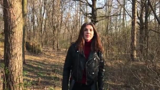 Jovem mulher bonita caminhando por um caminho na floresta de outono — Vídeo de Stock