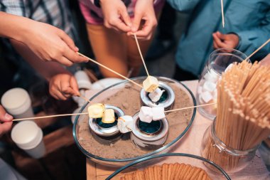 Bir tabloda bir düğün kısmında küçük bir ateş üzerinde Marshmallows sinirli