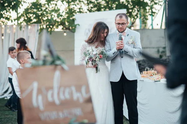 Sposa e sposo a una festa di nozze e un cavalletto in legno nel per — Foto Stock