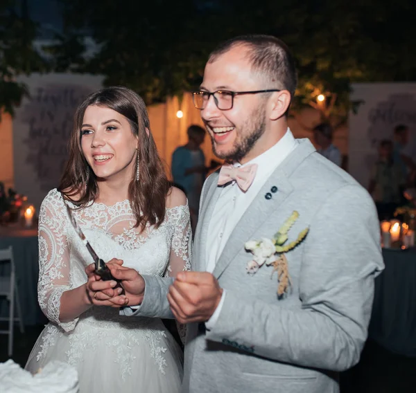 Bruden och brudgummen på festen skär och prova bröllopstårta — Stockfoto