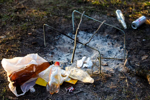 A pile of garbage in the forest park near the campfire site. environmental pollution