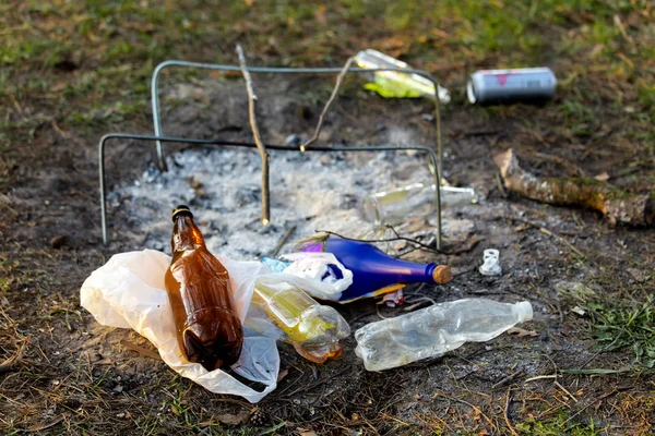 A pile of garbage in the forest park near the campfire site. environmental pollution