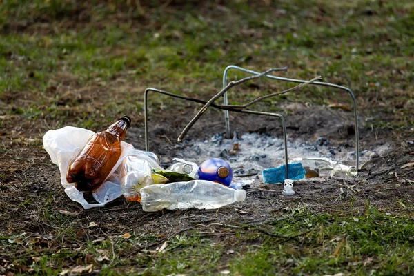 A pile of garbage in the forest park near the campfire site. environmental pollution