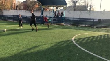 Lviv, Ukrayna - 14 Nisan 2019: Güneşli bir günde mini suni çim sahasında futbol oynayan erkekler