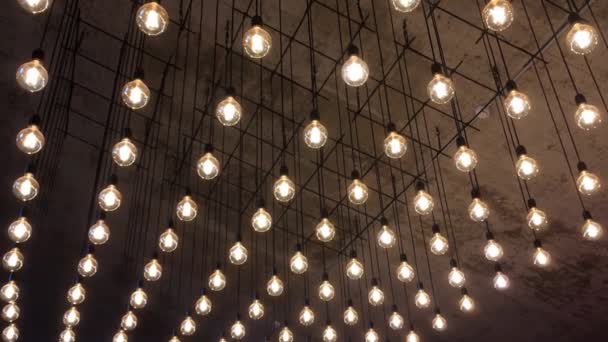 Éclairage à partir d'une variété d'ampoules à incandescence qui pendent au plafond et se déconcentrent — Video