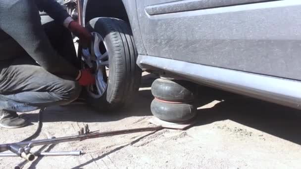 KYIV, UKRAINE - 21 de abril de 2019: Carro metálico cinza está no macaco para substituição de rodas em câmera lenta — Vídeo de Stock