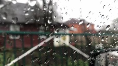 Bulutlu arka plan ile pencere gözlük yüzeyinde yağmur damlaları. Yağmur damlalarının doğal deseni. Yağmurda araba sürmek. Araba penceresinden damlalarla görüntüle.