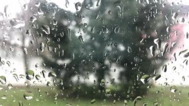 Bulutlu arka plan ile pencere gözlük yüzeyinde yağmur damlaları. Yağmur damlalarının doğal deseni. Yağmurda araba sürmek. Araba penceresinden damlalarla görüntüle.