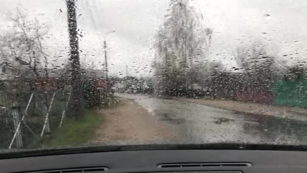 Szyba okienna, deszczowy dzień, krople deszczu na przednią szybę samochodu — Wideo stockowe