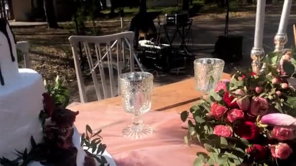 Lviv, Ukraina-april 14, 2019: vackra dekorativa bröllop bord med ljus, blommor och en tre-lager tårta av vit färg i naturen — Stockvideo