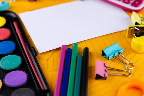 Schulbüro liefert Schreibwaren auf orangefarbenem Papierhintergrund — Stockfoto