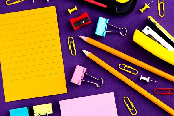 School office supplies stationery on a purple background desk wi