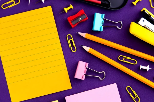 Schulbüro liefert Schreibwaren auf lila Hintergrund Schreibtisch wi — Stockfoto