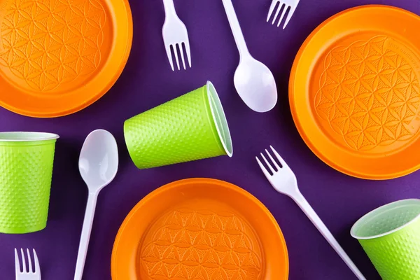 Пластиковые оранжевые зеленые отходы сбора на фиолетовом фоне. Conc — стоковое фото