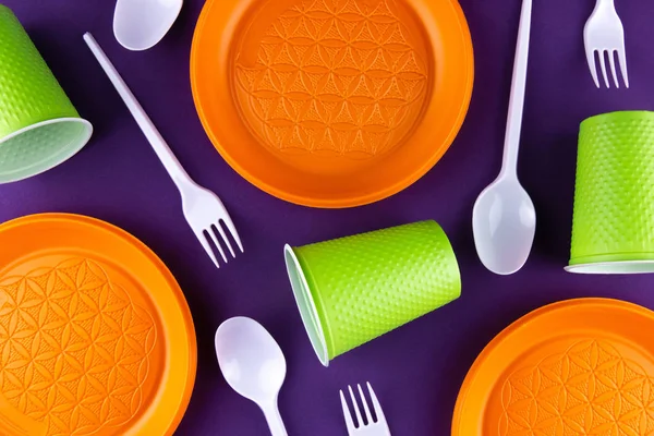 Plastic orange green waste collection on purple background. Conc