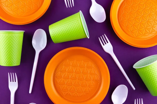 Пластиковые оранжевые зеленые отходы сбора на фиолетовом фоне. Conc — стоковое фото
