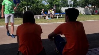 Korosten - Jule, 4, 2019: Kampta arkaları kameraya yan yana oturan genç adam ve kadın portresi