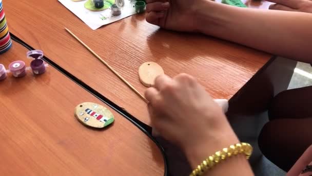 Tiro de close-up de uma criança pintando uma pequena redução de madeira na cor verde. Actividade artesanal — Vídeo de Stock