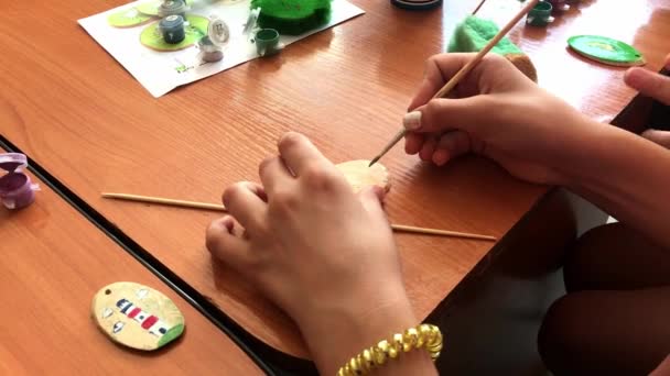 Κοντινό πλάνο ενός παιδιού που ζωγραφίζει ένα μικρό ξύλινο κόψιμο σε πράσινο χρώμα. Δραστηριότητες χειροτεχνίας — Αρχείο Βίντεο