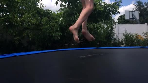 KOROSTEN - JULE, 4, 2019: pernas de menino em shorts pulando no trampolim ao ar livre — Vídeo de Stock