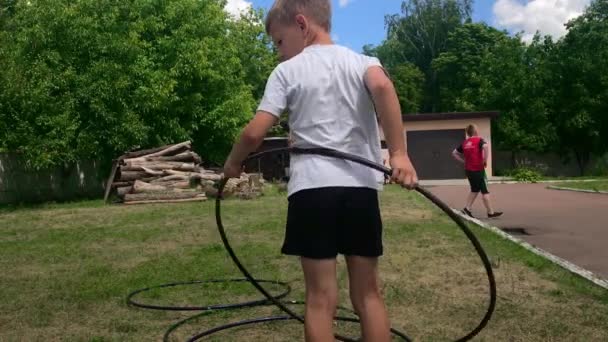 Korosten - 4. Juli 2019: Rückseite Nahaufnahme von Brust und Taille eines Jungen, der Hula-Hoop-Reifen-Ring im wunderschönen Morgengarten dreht. — Stockvideo