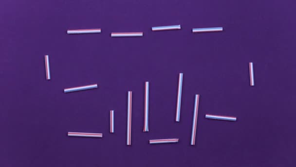 Animation stop motion. Word stop tubes en plastique et différentes cuillère et fourchette en plastique blanc fait cadre sur fond violet. Pollution de la terre, concept de recyclage — Video