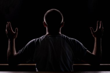 Kilisede oturur ve ha ile dua genç bir adamın silueti