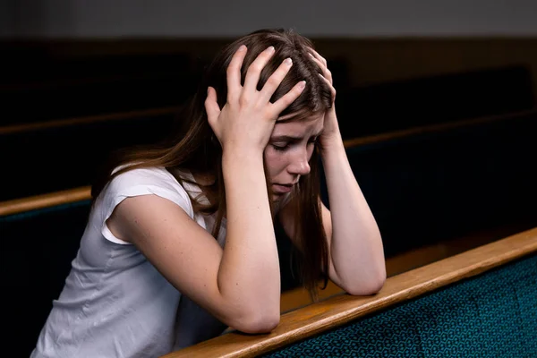 Una chica cristiana triste en camisa blanca está sentada y rezando con —  Fotos de Stock