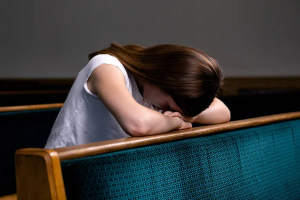 Una chica cristiana triste en camisa blanca está sentada y rezando con — Foto de Stock