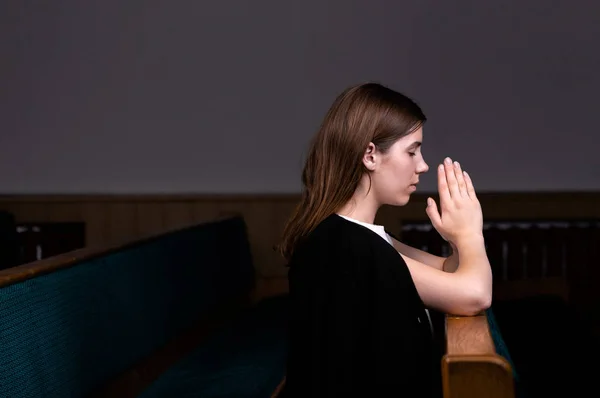 흰색 셔츠를 입은 기독교 소녀가 앉아서 험브로 기도하고 있습니다. — 스톡 사진