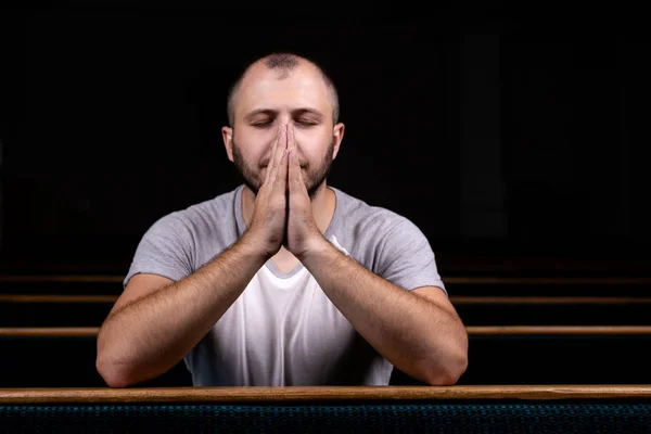 A Christian man in white shirt is sitting and praying with humbl — Stock Photo, Image