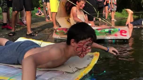 KOROSTEN - AUG, 12, 2019: youth teenage christian camp and active water games. swimming in the river. cardboard ship distillation — Stock Video